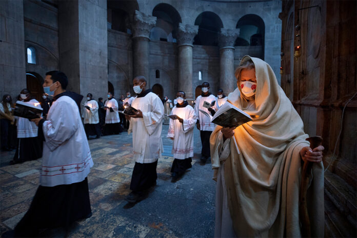 Priests circle the Edicule during Easter Sunday Mass led by the Latin Patriarch at the Church of the Holy Sepulchre, where many Christians believe Jesus was crucified, buried and rose from the dead, in the Old City of Jerusalem, Sunday, April 4, 2021. Photo: Oded Balilty / AP
