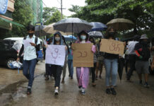 Myanmar Forces Arrest Comedian, Break up Doctors’ Protest Anti-coup protesters hold slogans which read "Rain Strike" as they use their umbrellas during a drizzle while participating in a demonstration in Yangon, Myanmar on Tuesday April 6, 2021. Photo: AP