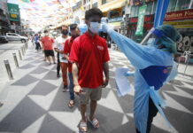 Bangkok Nightlife Clusters Expose Thailand’s Virus Stumbles A health worker checks the temperature of a man falling in line for a COVID-19 swab test in Khaosan Road in Bangkok, Thailand Wednesday, April 14, 2021. Photo: Somchai Chanjirakitti / AP