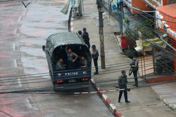 Police security forces stand by inside a police vehicle and on the sidewalk of Hledan Road in Kamayut township in Yangon, Myanmar Friday, April 16, 2021. Photo: AP