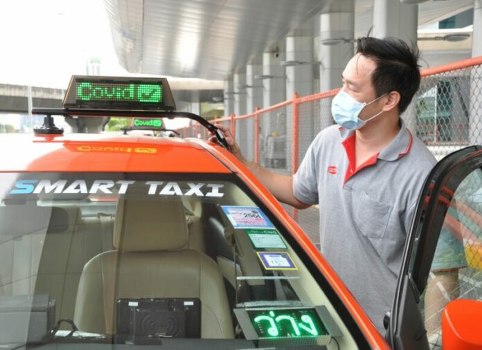 A taxi driver of a Smart Taxi shows off the sign on top of his vehicle on May 24, 2021, which indicates that he has been vaccinated against COVID-19.