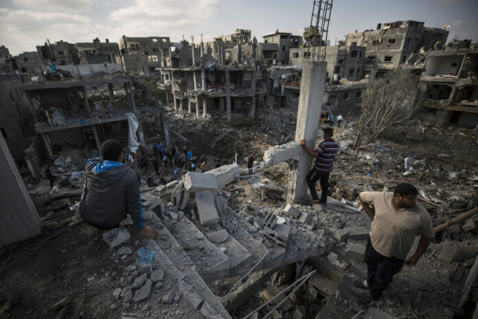 Palestinians inspect their destroyed houses following overnight Israeli airstrikes in town of Beit Hanoun, northern Gaza Strip, Friday, May 14, 2021. Photo: Khalil Hamra / AP