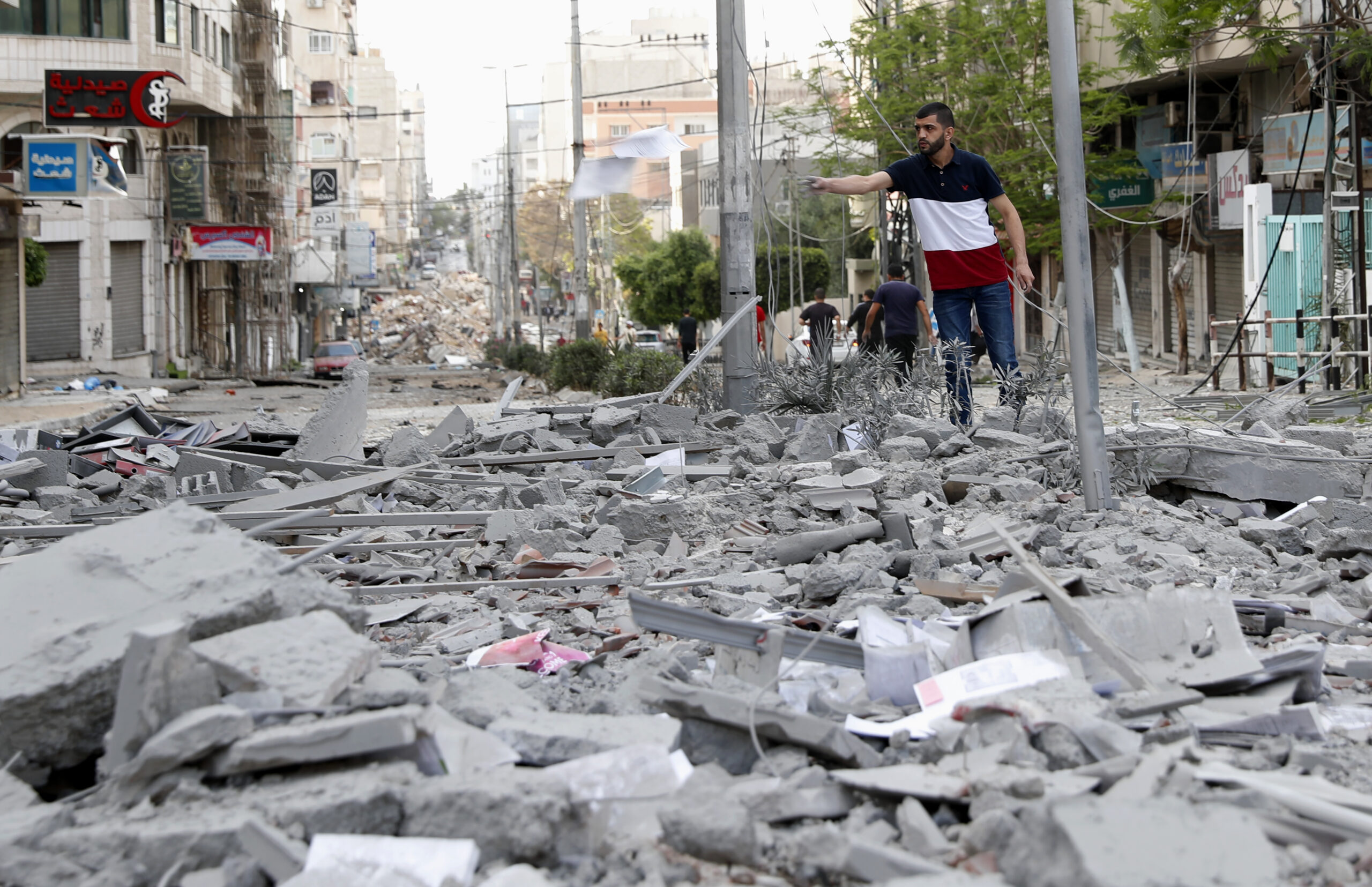 A man inspects the rubble of destroyed commercial building and Gaza health care clinic following an Israeli airstrike on the upper floors of a commercial building near the Health Ministry in Gaza City, on Monday, May 17, 2021. Photo: Adel Hana / AP