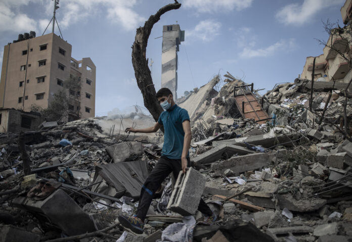 A Palestinian man inspects the damage of a six-story building which was destroyed by an early morning Israeli airstrike, in Gaza City, Tuesday, May 18, 2021. Photo: Khalil Hamra / AP A Palestinian man inspects the damage of a six-story building which was destroyed by an early morning Israeli airstrike, in Gaza City, Tuesday, May 18, 2021. Photo: Khalil Hamra / AP