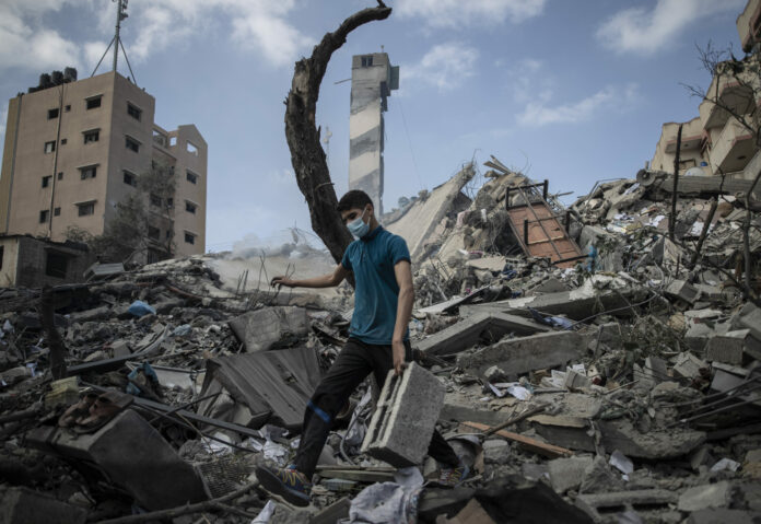 A Palestinian man inspects the damage of a six-story building which was destroyed by an early morning Israeli airstrike, in Gaza City, Tuesday, May 18, 2021. Photo: Khalil Hamra / AP