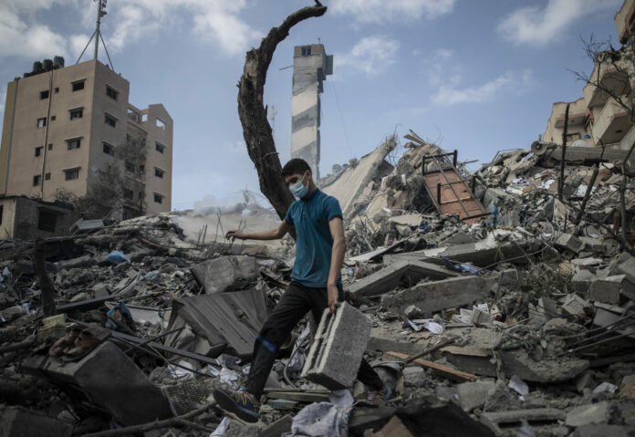 A Palestinian man inspects the damage of a six-story building which was destroyed by an early morning Israeli airstrike, in Gaza City, Tuesday, May 18, 2021. Photo: Khalil Hamra / AP A Palestinian man inspects the damage of a six-story building which was destroyed by an early morning Israeli airstrike, in Gaza City, Tuesday, May 18, 2021. Photo: Khalil Hamra / AP
