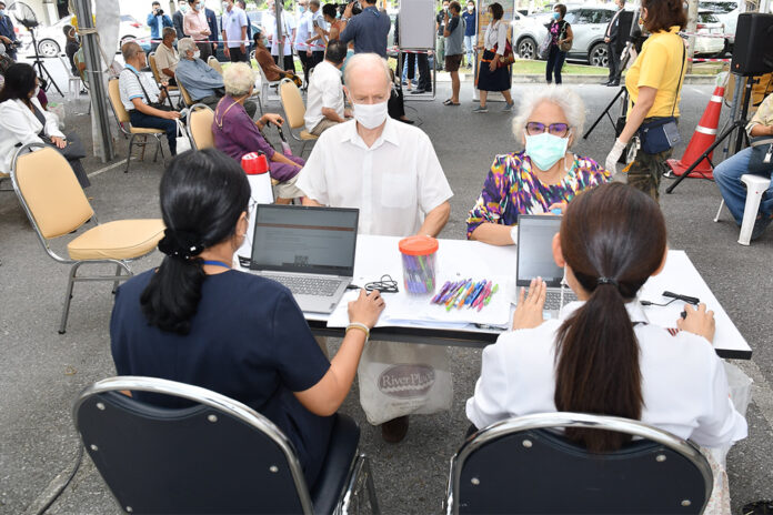 People wait to receive AstraZeneca COVID-19 vaccine at Chulabhorn Royal Academy on May 20, 2021.