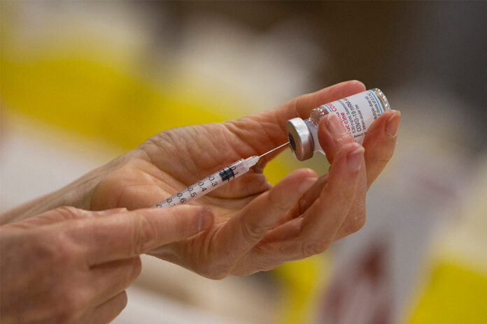 In this Wednesday, April 14, 2021 file photo, a pharmacist fills a syringe from a vial of the Moderna COVID-19 vaccine in Antwerp, Belgium. Photo: Virginia Mayo / AP In this Wednesday, April 14, 2021 file photo, a pharmacist fills a syringe from a vial of the Moderna COVID-19 vaccine in Antwerp, Belgium. Photo: Virginia Mayo / AP