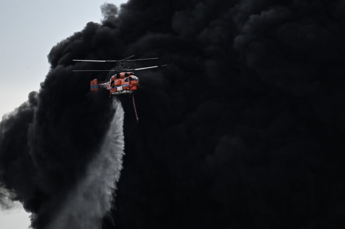A helicopter drops a fire-retardant in a massive factory fire in Samut Prakan province, Thailand, Monday, July 5, 2021.