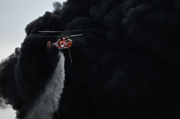 A helicopter drops a fire-retardant in a massive factory fire in Samut Prakan province, Thailand, Monday, July 5, 2021.