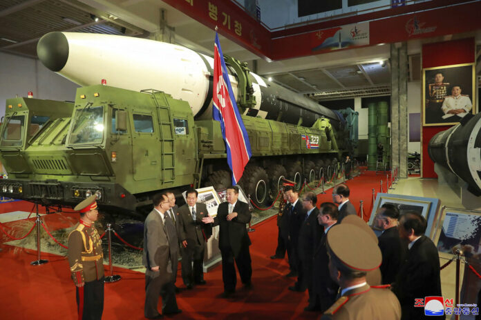 In this photo provided by the North Korean government, North Korean leader Kim Jong Un, center, speaks in front of what the North says an intercontinental ballistic missile displayed at an exhibition of weapons systems in Pyongyang, North Korea, Monday, Oct. 11, 2021. Independent journalists were not given access to cover the event depicted in this image distributed by the North Korean government. The content of this image is as provided and cannot be independently verified. Korean language watermark on image as provided by source reads: 