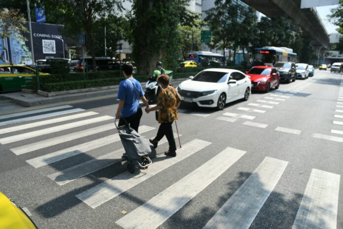 Pedestrians use a crosswalk in front of the Bhumirajanagarindra Kidney Institute Hospital in Bangkok, where ophthalmologist Waraluck Supwatjariyakul was fatally hit by a motorcycle, on Jan. 25, 2022.