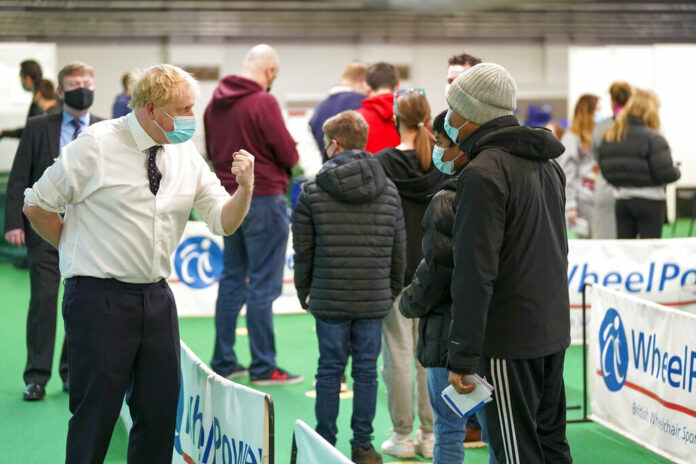 Britain's Prime Minister Boris Johnson, left, visits a vaccination hub in the at Stoke Mandeville Stadium in Aylesbury, England, Monday Jan. 3, 2022, as the booster vaccination programme continues. Photo: Steve Parsons / Pool via AP