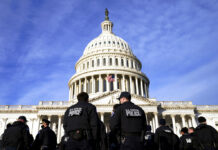 Biden Warns of US Peril From Trump’s ‘Dagger’ at Democracy A large group of police arrive at the Capitol, Thursday, Jan. 6, 2022, in Washington. Photo: Evan Vucci / AP