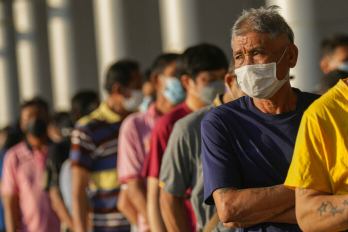 Local residents wait on line to receive shots of the Pfizer vaccine at the Central Vaccination Center in Bangkok, Thailand, Monday, Jan. 10, 2022. Photo: Sakchai Lalit / AP