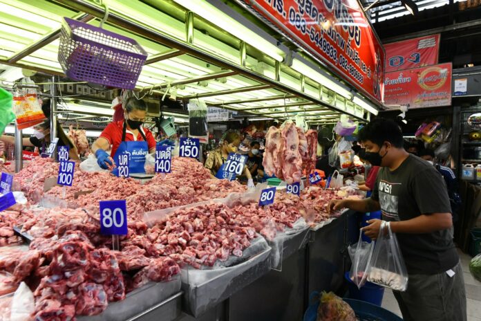 A customer shop for pork at Ying Charoen Market on Jan. 9, 2022.