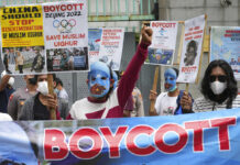Another Beijing Olympics With Human Rights Still Major Issue FILE - Student activists, some wearing masks with the colors of the pro-independence East Turkistan flag, shout slogans during a rally to protest the Beijing 2022 Winter Olympic Games, outside the Chinese Embassy in Jakarta, Indonesia on Jan. 14, 2022. Photo: Tatan Syuflana / AP File