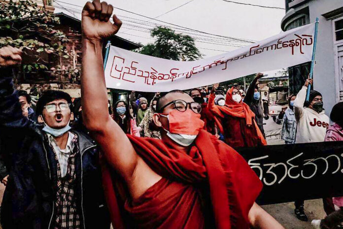 A Buddhist monk raises his clenched fist while marching during an anti-military government protest rally on Tuesday, Feb. 1, 2022, in Mandalay, Myanmar. Photo: AP