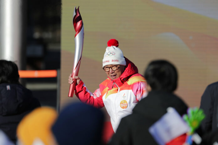 First Torch bearer Luo Zhihuan holds up the torch at the start of the torch relay for the 2022 Winter Olympics at the Olympic Forest Park in Beijing on Wednesday, Feb. 2, 2022. Photo: Sam McNeil / AP