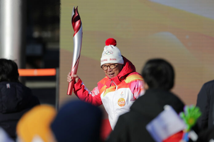 First Torch bearer Luo Zhihuan holds up the torch at the start of the torch relay for the 2022 Winter Olympics at the Olympic Forest Park in Beijing on Wednesday, Feb. 2, 2022. Photo: Sam McNeil / AP First Torch bearer Luo Zhihuan holds up the torch at the start of the torch relay for the 2022 Winter Olympics at the Olympic Forest Park in Beijing on Wednesday, Feb. 2, 2022. Photo: Sam McNeil / AP