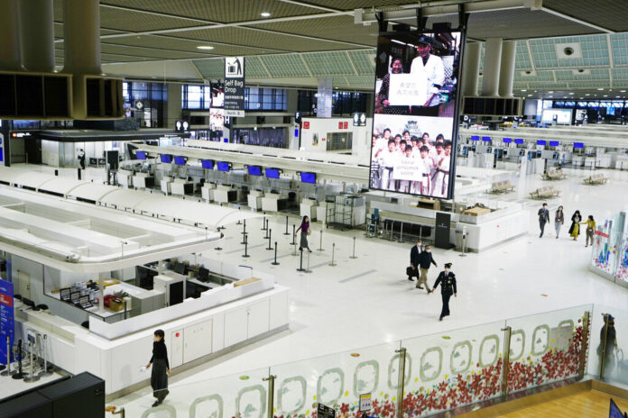 FILE - Passengers walk through the ticketing counter floor for international flights at the Narita International Airport in Narita, east of Tokyo, on Dec. 2, 2021. Photo: Hiro Komae / AP File