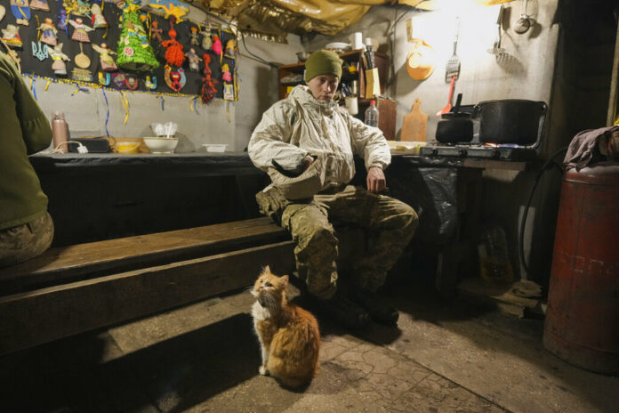 Good luck charms are pinned to a wall as a Ukrainian serviceman pauses in a bunker on a frontline position outside Avdiivka, Donetsk region, eastern Ukraine, Friday, Feb. 4, 2022. Photo: Vadim Ghirda / AP