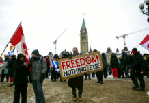 Canada Protests Sound Common Refrain: ‘We Stand For Freedom’ Don Stephens, 65, a retired graphic designer, holds a sign on Parliament Hill to support trucks lined up in protest of COVID-19 vaccine mandates and restrictions in Ottawa, Ontario, on Saturday, Feb. 12, 2022. Photo: Ted Shaffrey / AP