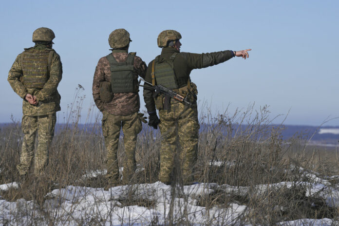 Ukrainian servicemen survey the impact areas from shells that landed close to their positions during the night on a front line outside Popasna, Luhansk region, eastern Ukraine, Monday, Feb. 14, 2022. Photo: Vadim Ghirda / AP
