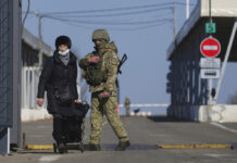 War Fears Grow as Putin Orders Troops to Eastern Ukraine A woman crosses a checkpoint from the territory controlled by Russia-backed separatists to the territory controlled by Ukrainian forces in Novotroitske, eastern Ukraine, Monday, Feb. 21, 2022. Photo: Evgeniy Maloletka / AP