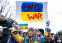 World Leaders Slap Sanctions on the Kremlin Over Invasion A tear rolls down through the colors of the Ukrainian flag on the cheek of Ukranian Oleksandra Yashan of Arlington, Va., as she becomes emotional while holding a sign that reads "No War" during a vigil to protest the Russian invasion of Ukraine in Lafayette Park in front of the White House in Washington, Thursday, Feb. 24, 2022. Photo: Andrew Harnik / AP