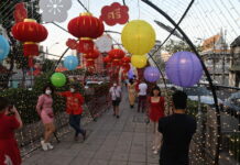 Opinion: Are Thais Becoming Too Chinese? People pose with Chinese New Year display in Yaowarat on Feb. 1, 2022.