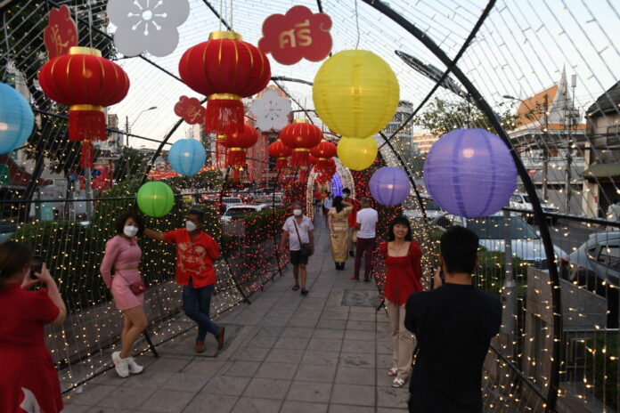 People pose with Chinese New Year display in Yaowarat on Feb. 1, 2022.