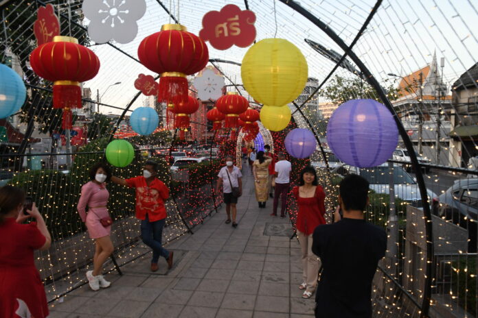 People pose with Chinese New Year display in Yaowarat on Feb. 1, 2022. People pose with Chinese New Year display in Yaowarat on Feb. 1, 2022.