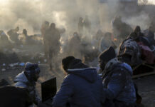 As Non-Ukrainians Also Flee War, Some Report Mistreatment Refugees try to stay warm after fleeing the Russian invasion of Ukraine, at the Medyka border crossing in Poland, Tuesday, March 1, 2022. Photo: Visar Kryeziu / AP