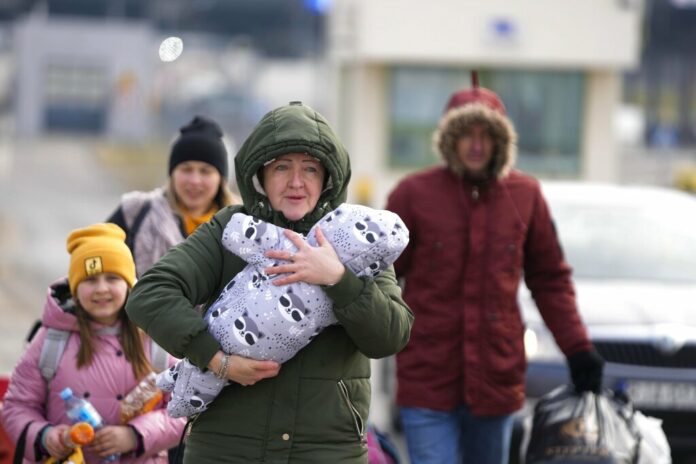 A family arrive at the border crossing in Medyka, Poland, Wednesday, March 2, 2022, after fleeing from the Ukraine. Photo: Markus Schreiber / AP