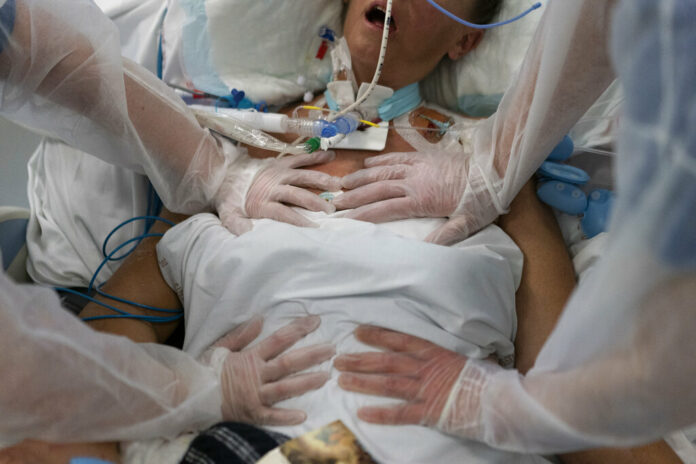 FILE - Nurses perform timed breathing exercises on a COVID-19 patient on a ventilator in the COVID-19 intensive care unit at the la Timone hospital in Marseille, southern France, Friday, Dec. 31, 2021. Photo: Daniel Cole / AP File