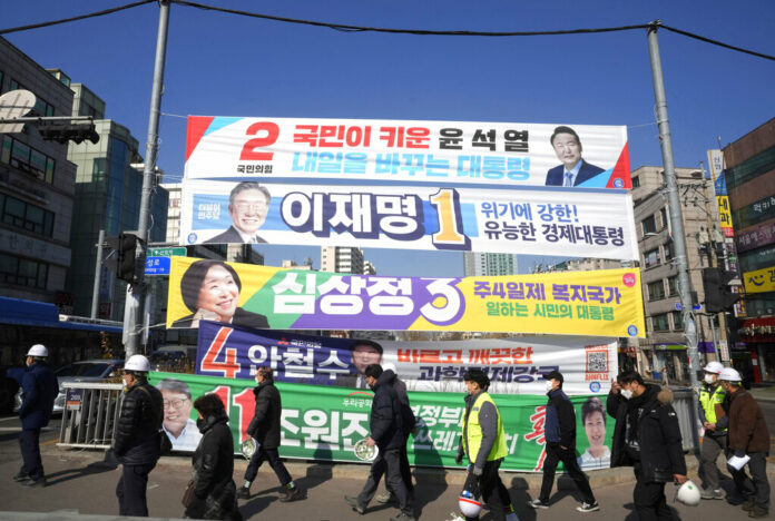 Placards featuring ruling and opposition presidential candidates hang over a street in Seoul, South Korea on Feb. 17, 2022. Photo: Ahn Young-joon / AP Placards featuring ruling and opposition presidential candidates hang over a street in Seoul, South Korea on Feb. 17, 2022. Photo: Ahn Young-joon / AP