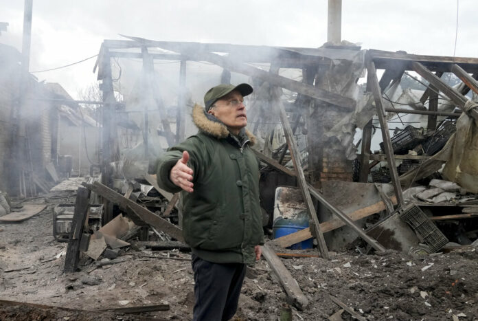A man opens his arms as he stands near a house destroyed in the Russian artillery shelling, in the village of Horenka close to Kyiv, Ukraine, Sunday, March 6, 2022. Photo: Efrem Lukatsky / AP