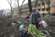Airstrike Hits Ukraine Maternity Hospital, 17 Reported Hurt A woman walks outside the damaged by shelling maternity hospital in Mariupol, Ukraine, Wednesday, March 9, 2022. Photo: Evgeniy Maloletka / AP