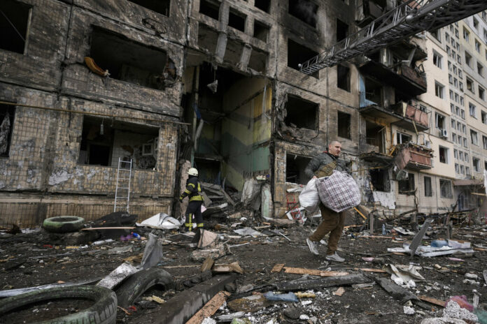 A local resident searches for his belongings in an apartment building after it was hit by artillery shelling in Kyiv, Ukraine, Monday, March 14, 2022. Photo: Vadim Ghirda / AP