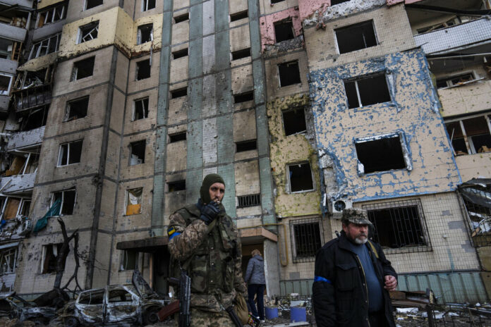 A soldier smokes a cigarette while walking next to a destroyed building after a bombing in Satoya neighborhood in Kyiv, Ukraine, Sunday, March 20, 2022. Photo: Rodrigo Abd / AP