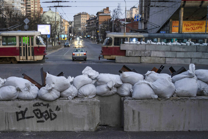 FILE - A driver passes through a barricade built by territorial defense units downtown in Kyiv, Ukraine, March 19, 2022. Photo: Rodrigo Abd / AP