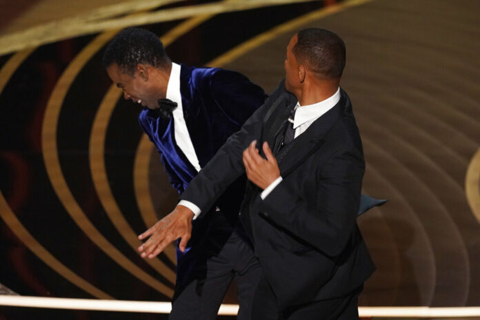 Will Smith, right, hits presenter Chris Rock on stage while presenting the award for best documentary feature at the Oscars on Sunday, March 27, 2022, at the Dolby Theatre in Los Angeles. Photo: Chris Pizzello / AP Will Smith, right, hits presenter Chris Rock on stage while presenting the award for best documentary feature at the Oscars on Sunday, March 27, 2022, at the Dolby Theatre in Los Angeles. Photo: Chris Pizzello / AP