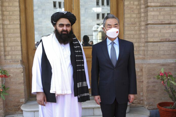 In this photo released by Xinhua News Agency, Chinese Foreign Minister Wang Yi, right, poses for photos with Amir Khan Muttaqi, acting foreign minister of the Afghan Taliban's caretaker government, in Kabul, Afghanistan on March 24, 2022. Photo: Saifurahman Safi / Xinhua via AP