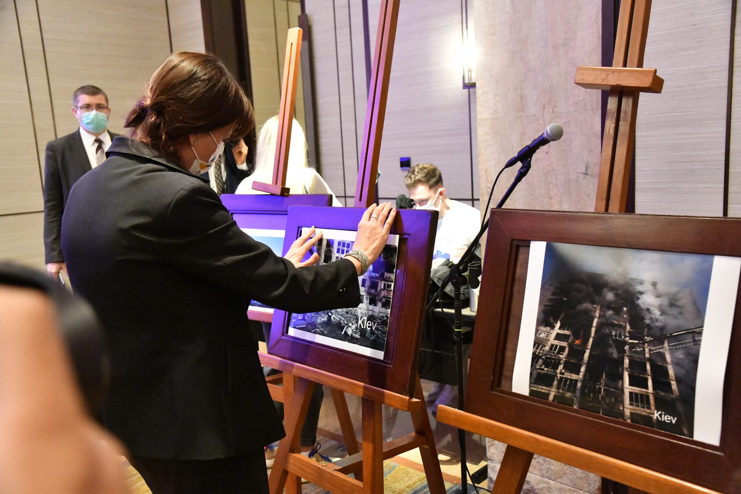 A woman looks at one of the photographs showing destruction in Ukraine on display at the event.