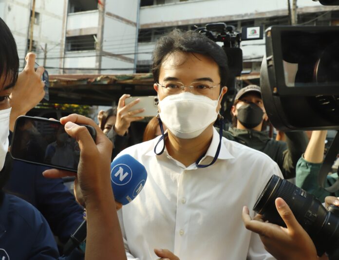 Former Democrat Party deputy leader Prinn Panitchpakdi being surrounded by reporters as he reports himself at Lumpini Police Station on Apr. 17, 2022.