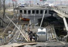 Russians Leave Chernobyl; Ukraine Braces for Renewed Attacks Ukrainian soldiers carry a body of a civilian killed by the Russian forces over the destroyed bridge in Irpin close to Kyiv, Ukraine, Thursday, March 31, 2022. Photo: Efrem Lukatsky / AP