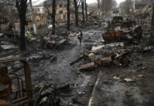 Ukraine Accuses Russia of Massacre, City Strewn With Bodies A woman walks amid destroyed Russian tanks in Bucha, in the outskirts of Kyiv, Ukraine, Sunday, April 3, 2022. Photo: Rodrigo Abd / AP