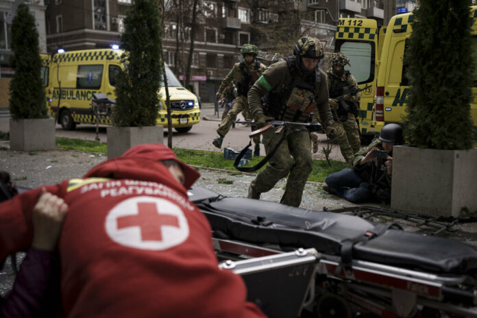 Ukrainian servicemen run for cover as explosions are heard during a Russian attack in downtown Kharkiv, Ukraine, Sunday, April 17, 2022. Photo: Felipe Dana / AP