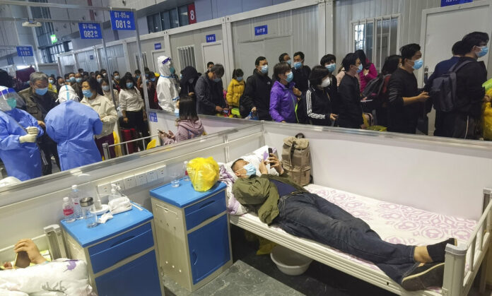 People who have been negative in the last two nucleic acid tests line up to leave a temporary hospital converted from the National Exhibition and Convention Center to quarantine COVID-positive people in Shanghai, China on April 18, 2022. Photo: Chinatopix via AP People who have been negative in the last two nucleic acid tests line up to leave a temporary hospital converted from the National Exhibition and Convention Center to quarantine COVID-positive people in Shanghai, China on April 18, 2022. Photo: Chinatopix via AP
